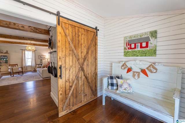 mudroom featuring hardwood / wood-style floors, a barn door, beamed ceiling, and wooden walls