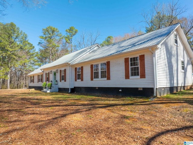 view of property exterior featuring crawl space, metal roof, and a yard