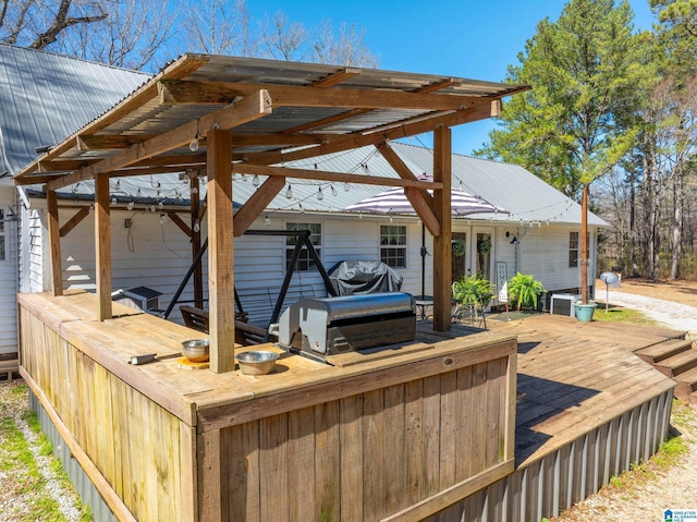 deck with a carport, area for grilling, and grilling area