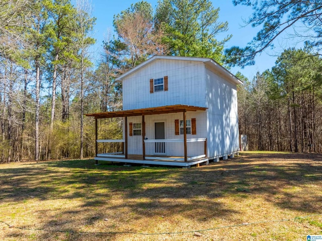 exterior space with a front yard and a wooded view