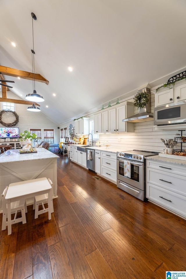 kitchen with dark wood finished floors, stainless steel appliances, white cabinets, wall chimney range hood, and lofted ceiling