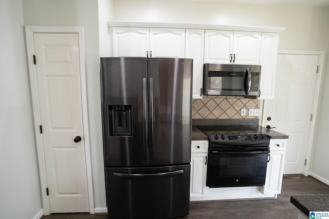 kitchen featuring dark countertops, decorative backsplash, white cabinets, stainless steel appliances, and dark wood-style flooring