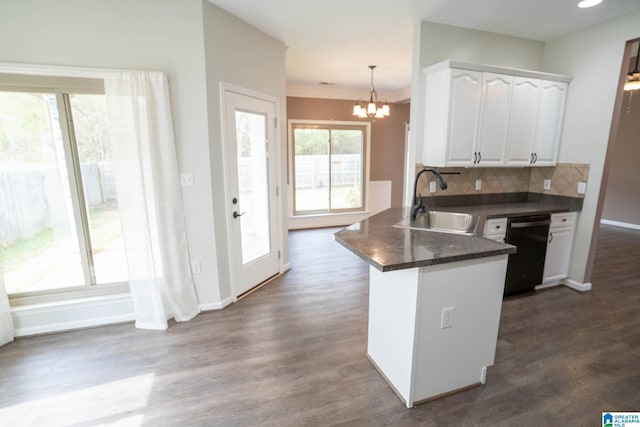 kitchen featuring a sink, dark countertops, a peninsula, white cabinets, and dishwasher