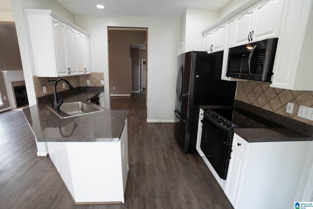 kitchen featuring black appliances, white cabinets, a peninsula, and a sink