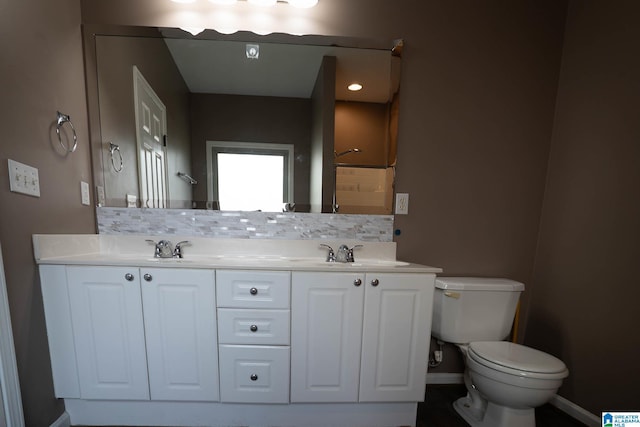 full bathroom with baseboards, toilet, double vanity, decorative backsplash, and a sink