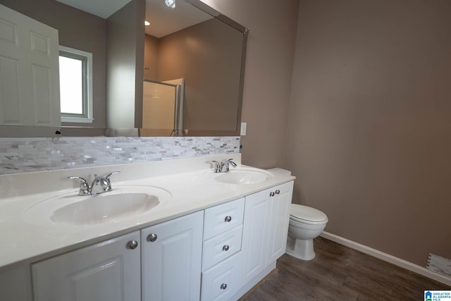 full bathroom with double vanity, toilet, wood finished floors, and a sink