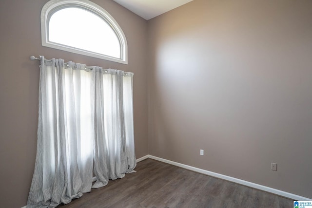 empty room featuring wood finished floors and baseboards