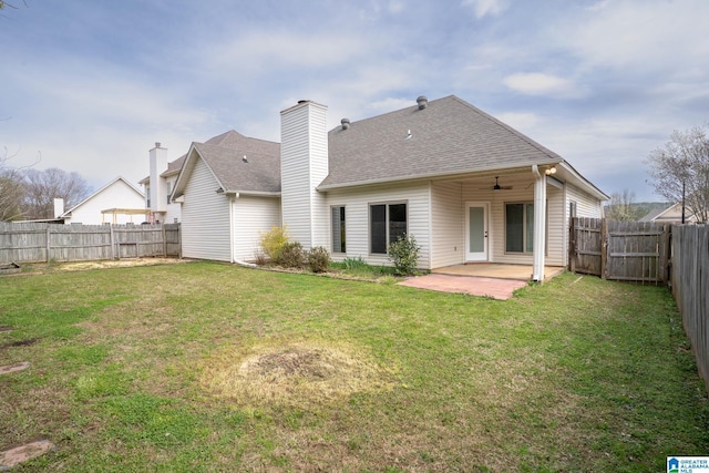 rear view of house featuring a patio area, a lawn, a ceiling fan, and a fenced backyard