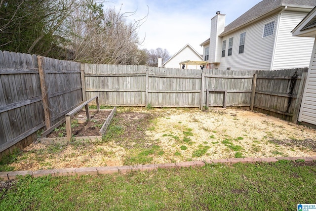 view of yard with a vegetable garden and a fenced backyard