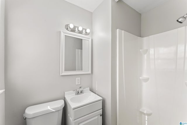 bathroom featuring a shower, toilet, and vanity