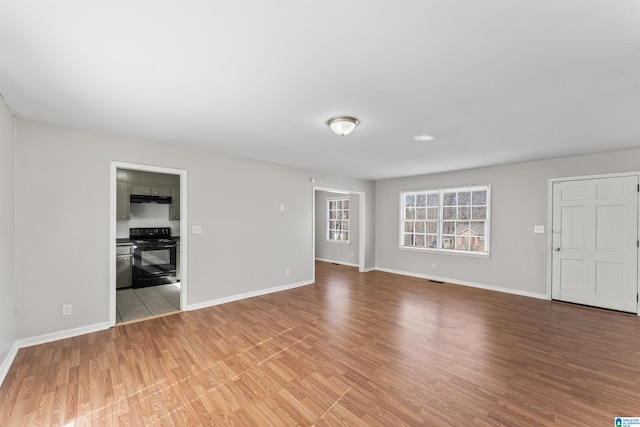 unfurnished living room featuring light wood-style flooring and baseboards