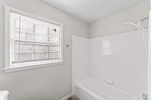 bathroom with toilet and washtub / shower combination