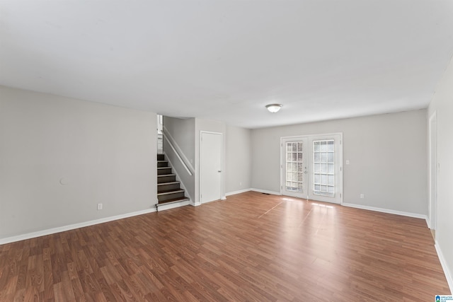 interior space featuring stairway, french doors, baseboards, and wood finished floors