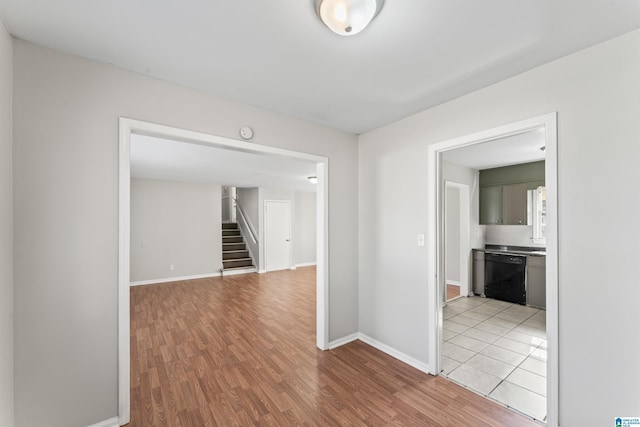 interior space with stairway, light wood-style floors, and baseboards