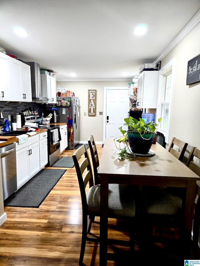 dining area with light wood-style flooring, recessed lighting, baseboards, and ornamental molding