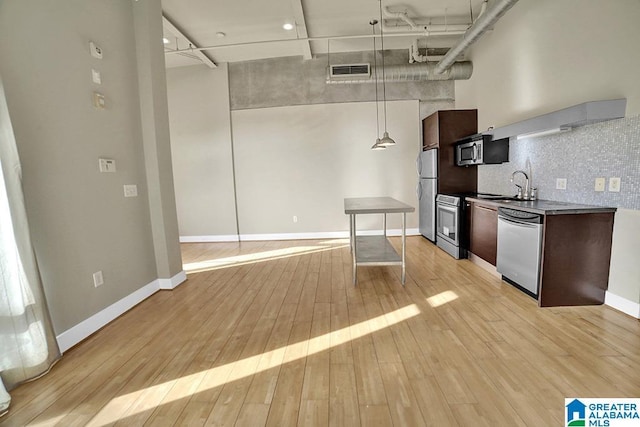 kitchen with tasteful backsplash, visible vents, light wood-style flooring, appliances with stainless steel finishes, and a sink