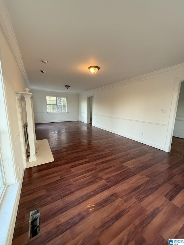 unfurnished living room with a fireplace with flush hearth, dark wood-type flooring, baseboards, and ornamental molding