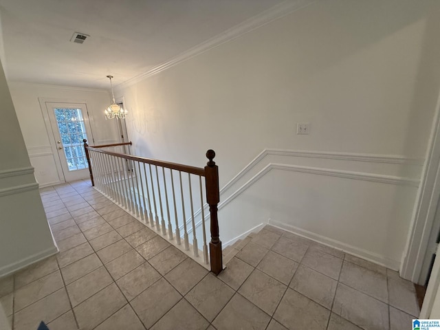 stairs featuring tile patterned floors, a notable chandelier, visible vents, and ornamental molding