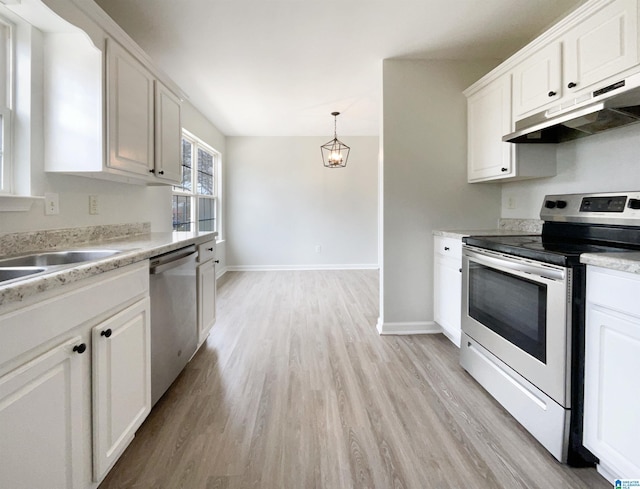 kitchen with under cabinet range hood, white cabinets, appliances with stainless steel finishes, and light countertops