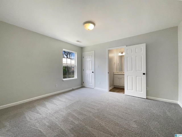 unfurnished bedroom featuring carpet flooring, visible vents, connected bathroom, and baseboards