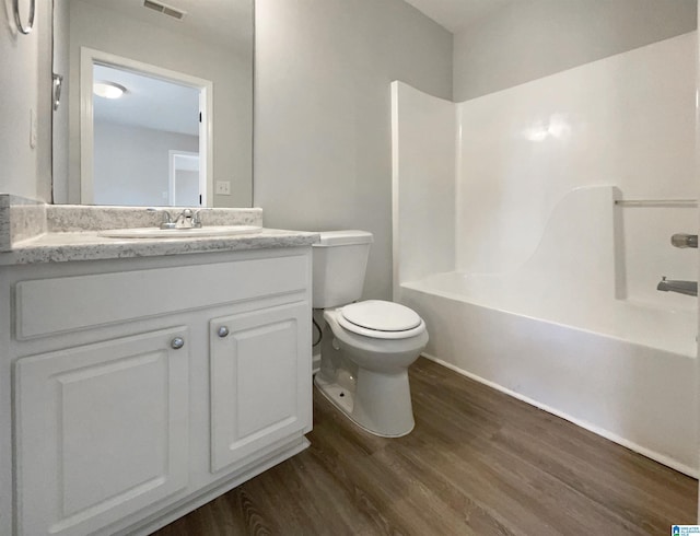 full bath with vanity, wood finished floors, visible vents,  shower combination, and toilet