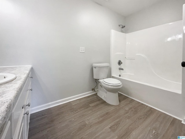 full bathroom featuring vanity, wood finished floors, baseboards, shower / washtub combination, and toilet