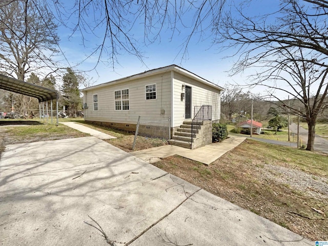 view of property exterior featuring crawl space, a detached carport, and concrete driveway