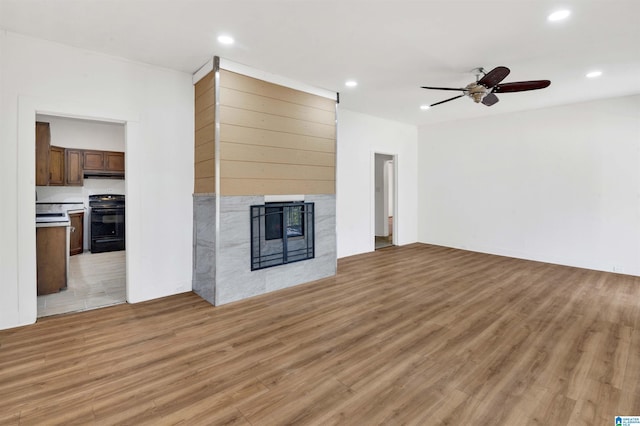 unfurnished living room with a fireplace, recessed lighting, light wood-style floors, and a ceiling fan