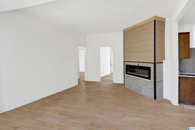 unfurnished living room featuring light wood-style floors, visible vents, and a large fireplace