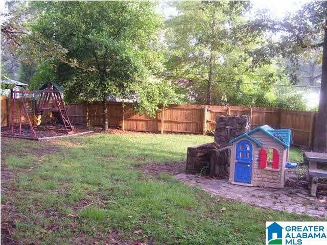 view of yard with a playground and a fenced backyard