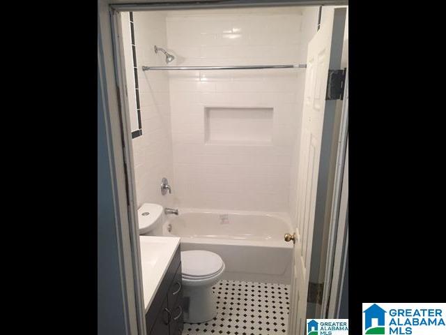 full bath featuring vanity,  shower combination, toilet, and tile patterned flooring