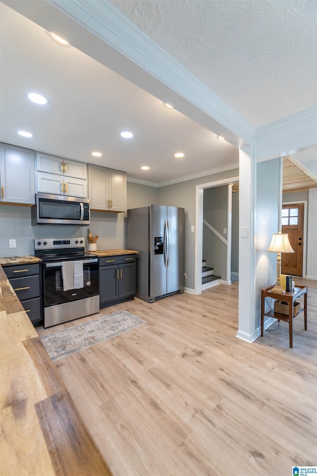 kitchen with ornamental molding, light wood-style floors, recessed lighting, and stainless steel appliances