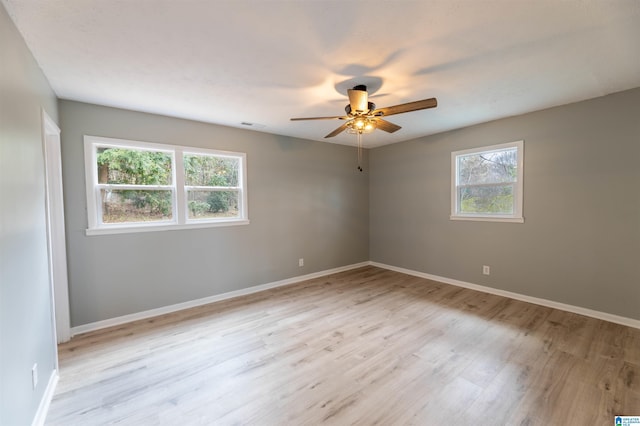 unfurnished room with baseboards, light wood-style floors, and a ceiling fan