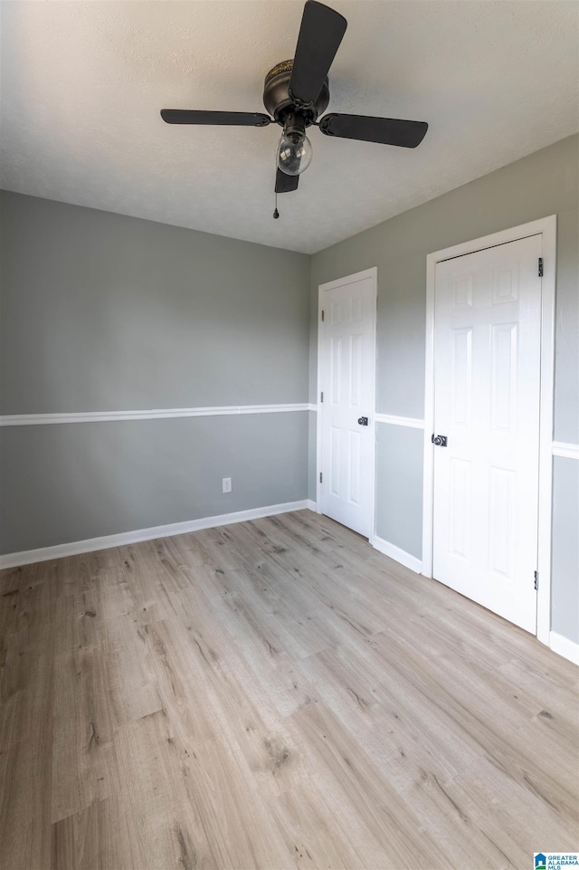 unfurnished bedroom featuring light wood finished floors, ceiling fan, and baseboards