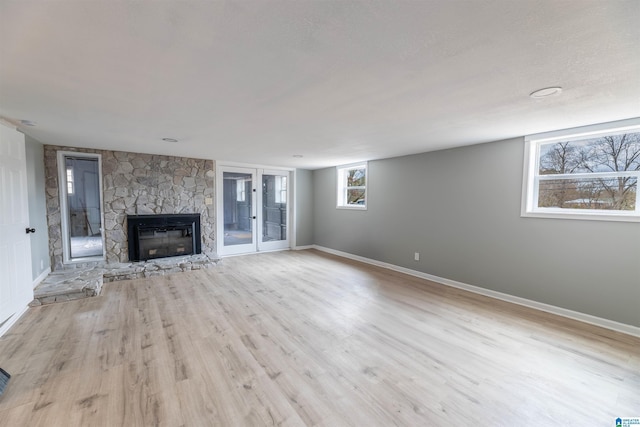 unfurnished living room featuring baseboards, light wood-style flooring, and a fireplace