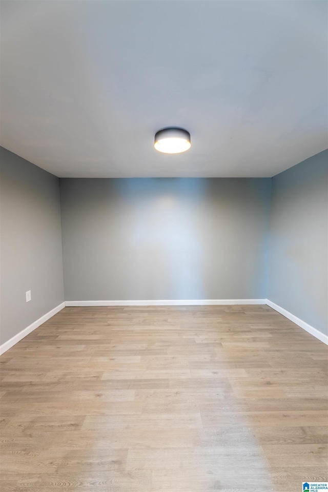 spare room featuring light wood-type flooring and baseboards