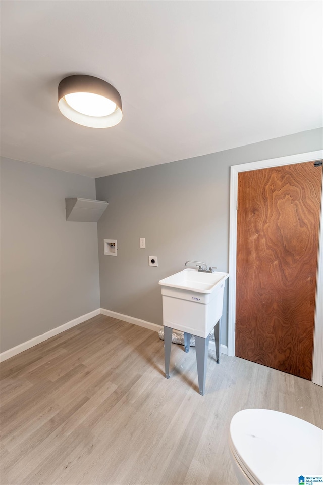 bathroom featuring baseboards, toilet, and wood finished floors