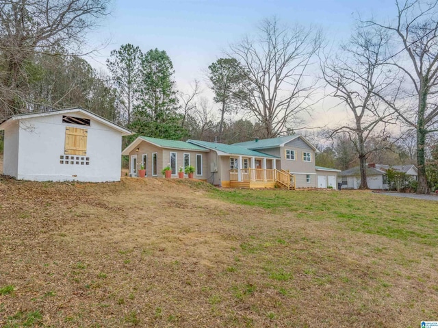 rear view of property with metal roof and a yard