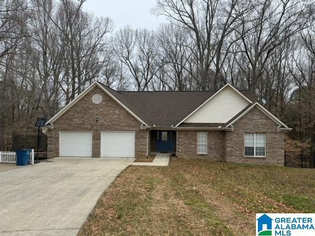 ranch-style house featuring a garage, brick siding, concrete driveway, and fence