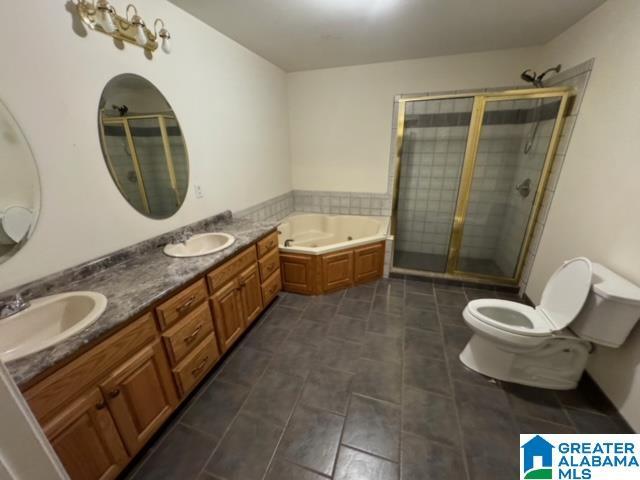 full bath featuring a shower stall, a jetted tub, toilet, and a sink