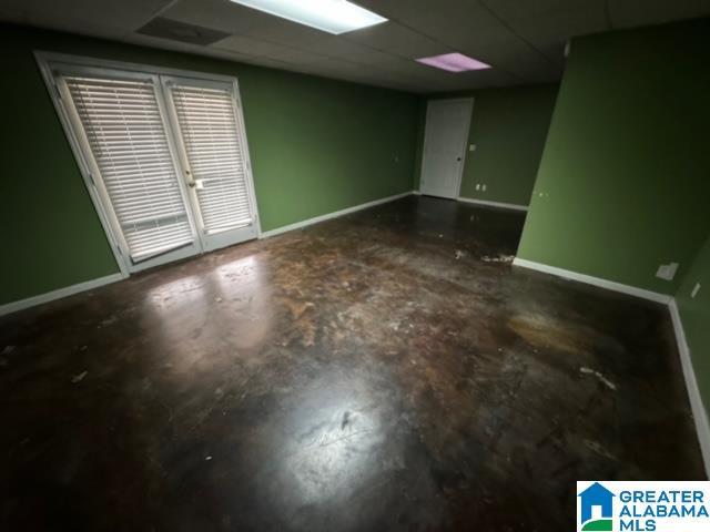 unfurnished room featuring concrete floors and baseboards