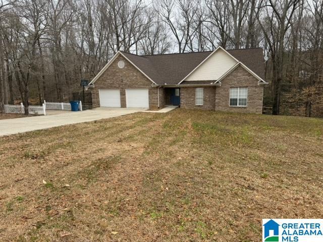 ranch-style house with driveway, a front yard, a garage, and fence