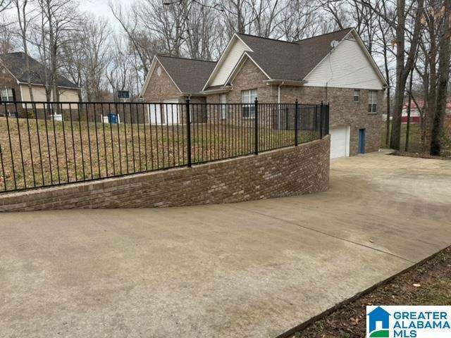 exterior space with an attached garage, driveway, and fence