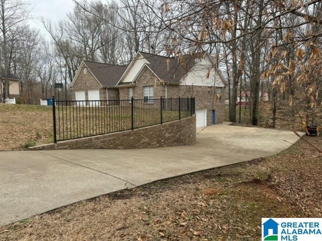 view of front of home with a garage, driveway, and fence