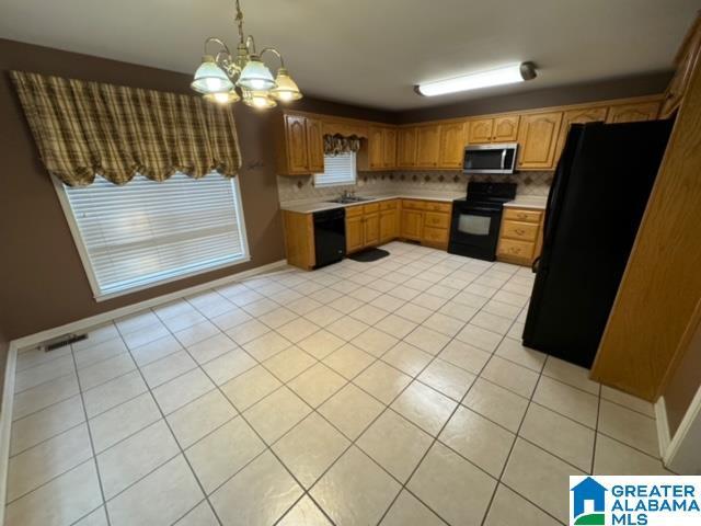 kitchen with decorative backsplash, black appliances, light countertops, and visible vents