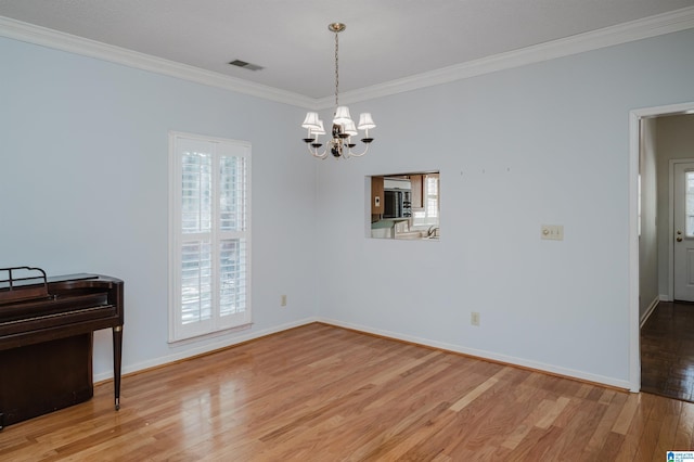 interior space with light wood-type flooring, visible vents, ornamental molding, baseboards, and a chandelier