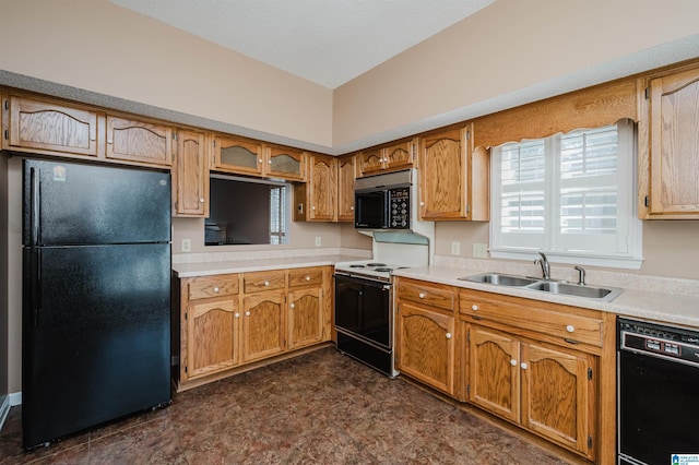 kitchen featuring brown cabinets, black appliances, light countertops, and a sink