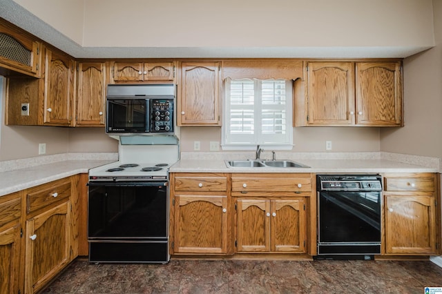 kitchen with a sink, black appliances, brown cabinetry, and light countertops