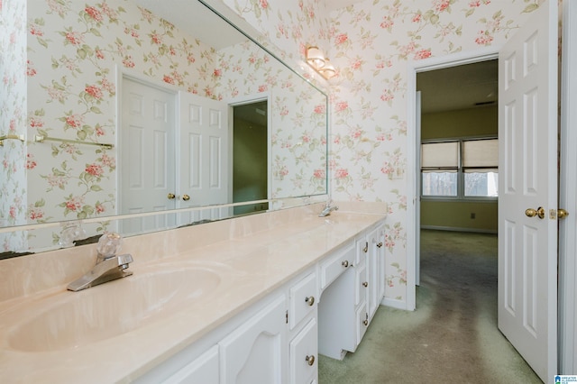 bathroom featuring a sink, baseboards, double vanity, and wallpapered walls