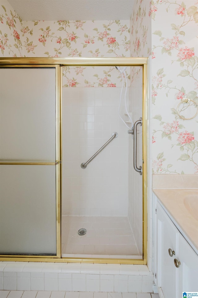 full bathroom featuring wallpapered walls, vanity, and a stall shower